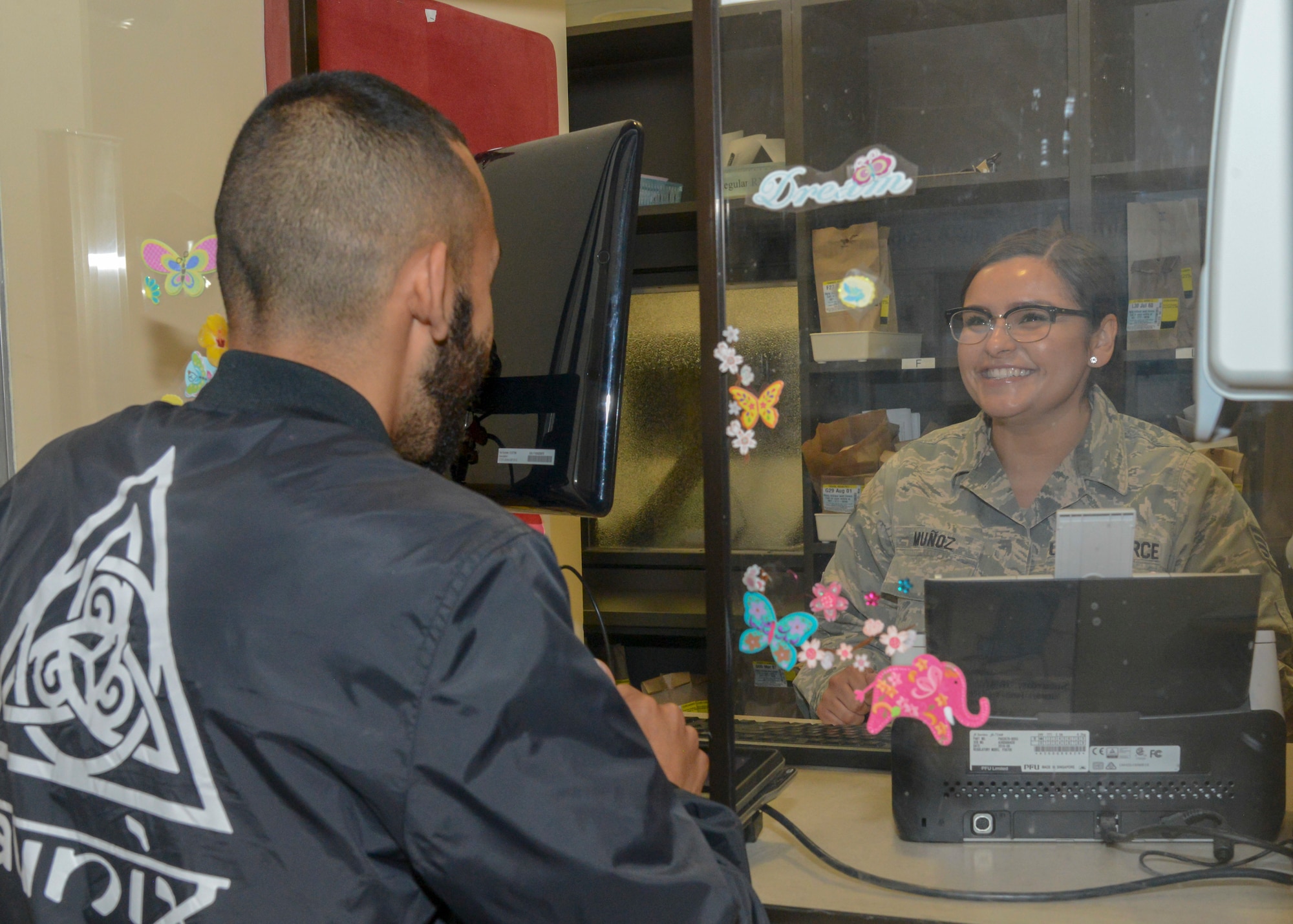 Pharmacy technician, Staff Sgt. Jessenya Munoz, 412th Medical Group, greets a customer at the Base Main Clinic Pharmacy Office at Edwards Air Force Base, Calif. The 412th MDG is currently looking for local high school students to participate in the Summer Youth Volunteer Program. (U.S. Air Force photo by Giancarlo Casem)