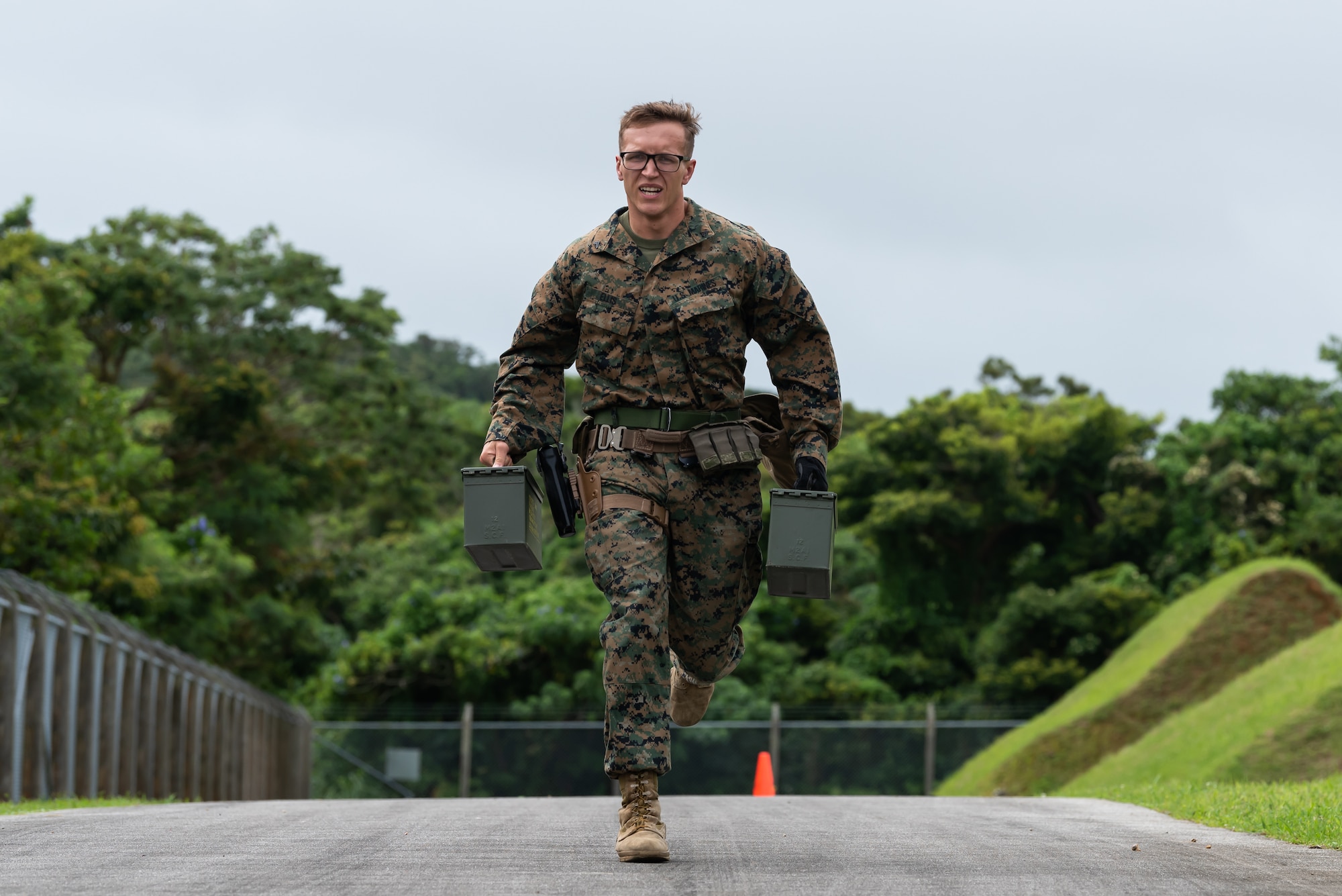 A U.S. Marine assigned to the Provost Marshal Office, carries ammo cans during a stress fire competition May 17, 2019, at Kadena Air Base, Japan.