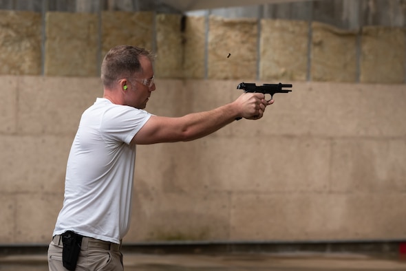A U.S. Air Force Airman assigned to the 18th Security Forces Squadron, fires an M9 pistol during a stress fire competition May 17, 2019, at Kadena Air Base, Japan.