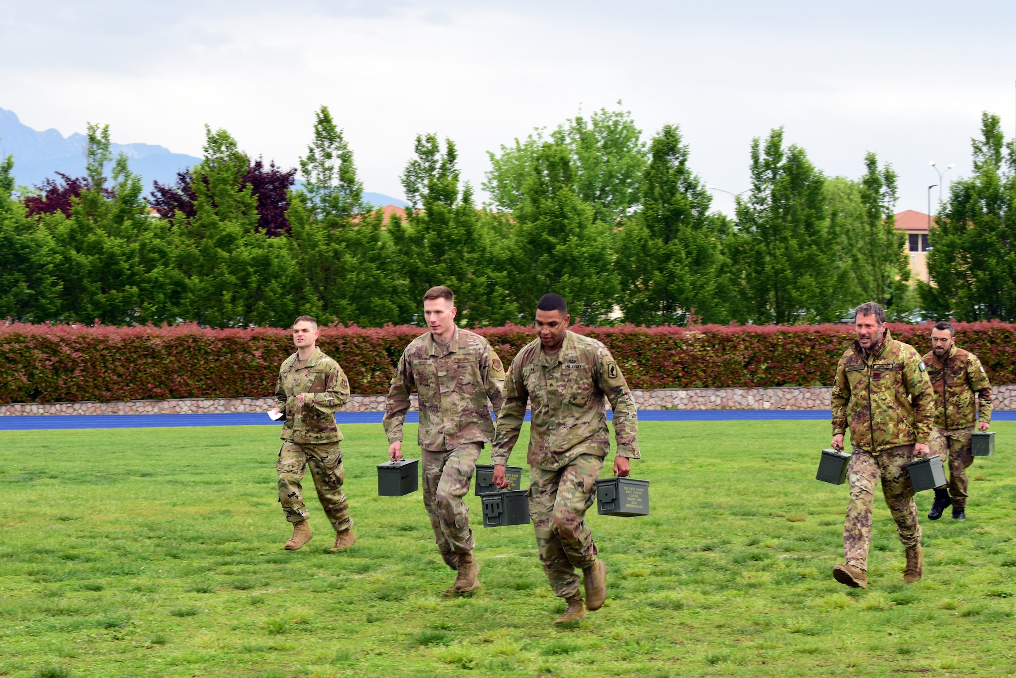 U.S. Air Force and Army members and Italian Air Force members carry ammo cans as they run to the next task during the Police Week Combat Challenge that pit security forces Airmen against Joint International Non Commissioned Officer Development Course held May 15, 2019 at Aviano Air Base, Italy. The combat challenge was a friendly competition to promote teamwork among the service members. (U.S. Air Force photo by Airman 1st Class Caleb House)