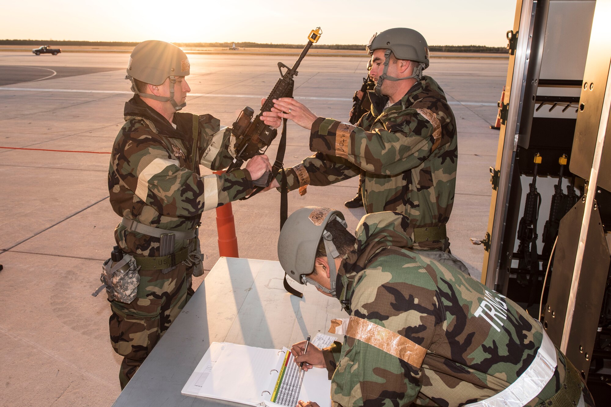 Staff Sgt. Wyatt Baldwin, standing right, issues a training weapon from the 167th Logistics Readiness Squadron’s mobile weapons’ vault during a  training exercise at Alpena Combat Readiness Training Center, Alpena, Mich., May 8, 2019. Approximately 300 167th AW Airmen participated in the training event. (U.S. Air National Guard photo by Tech. Sgt. Jodie Witmer)