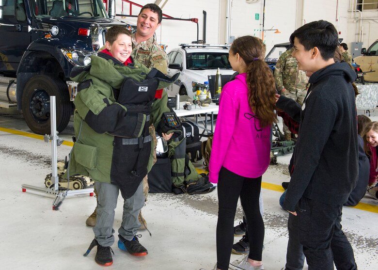 Staff Sgt. Trenton Hawk, a 434th Civil Engineer Squadron technician, helps a student try on a bomb suit during a police week event at Grissom Air Reserve Base, Ind., May 13, 2019. Students from area schools visited the base and participated in briefings and demonstrations from various law enforcement agencies throughout the state. 
(U.S. Air Force photo by Staff Sgt. Courtney Dotson-Essett)