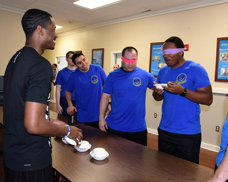 Two team members of the 14th Contracting Squadron work together to guess different food while blindfolded during the A-BLAZIN’ Race May 10, 2019, on Columbus Air Force Base, Miss. Nine stations were set up in various locations around base with different challenges attached to each station. (U.S. Air Force photo by Elizabeth Owens)