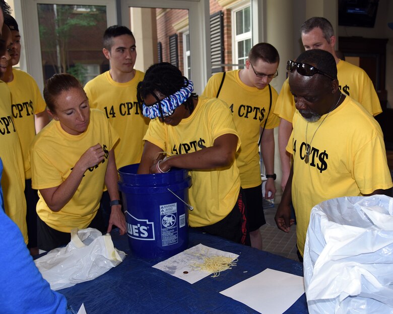 The 14th Comptroller Squadron team works with their teammate to hunt down coins in a bucket of noodles while blindfolded during the A-BLAZIN’ Race May 10, 2019, on Columbus Air Force Base, Miss. Challenges included an alpha warrior challenge, a gross food challenge, a coin challenge and so much more. (U.S. Air Force photo by Sharon Ybarra)