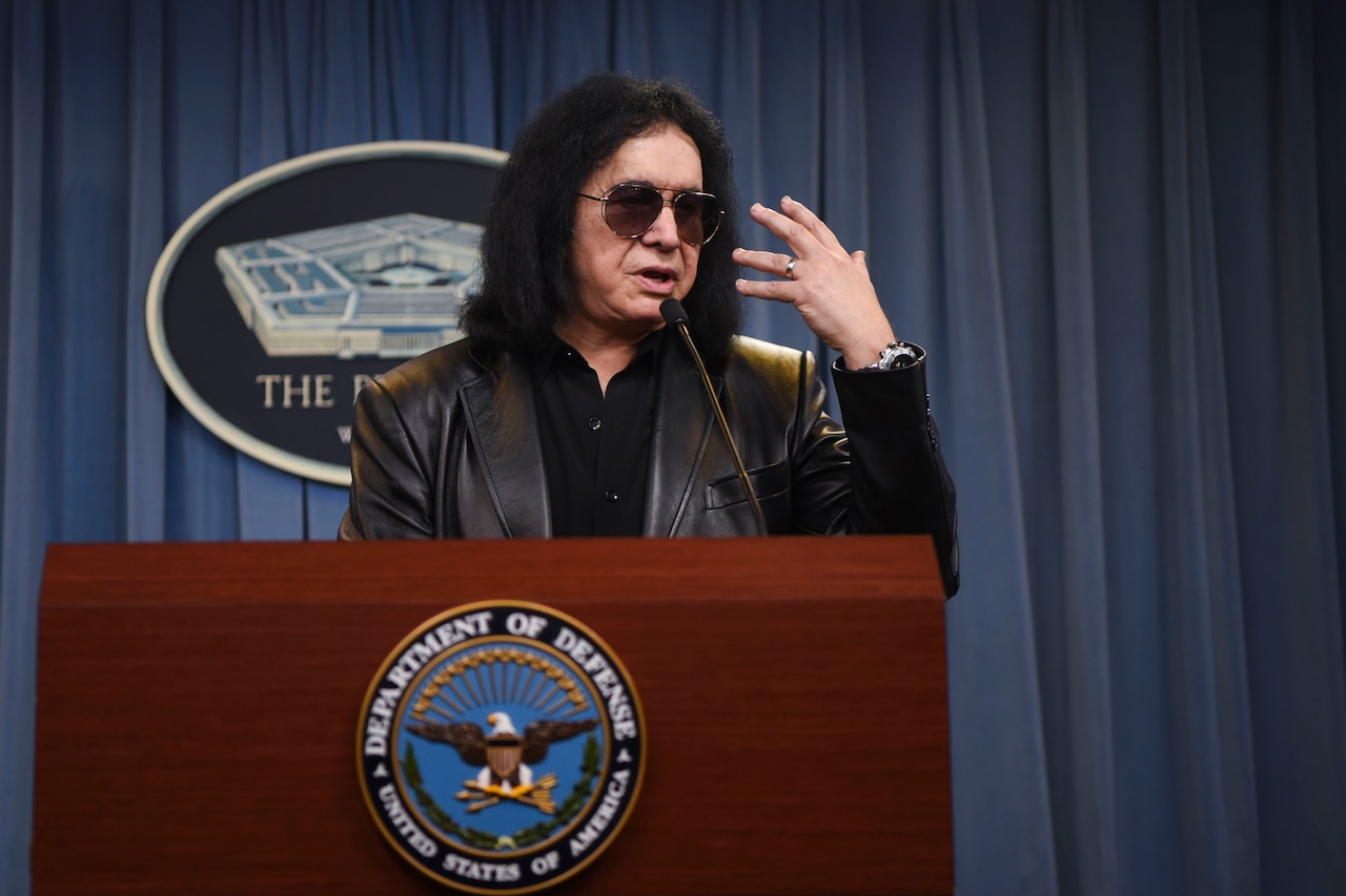 Famous musician Gene Simmons stands at a podium in the  pentagon briefing room.