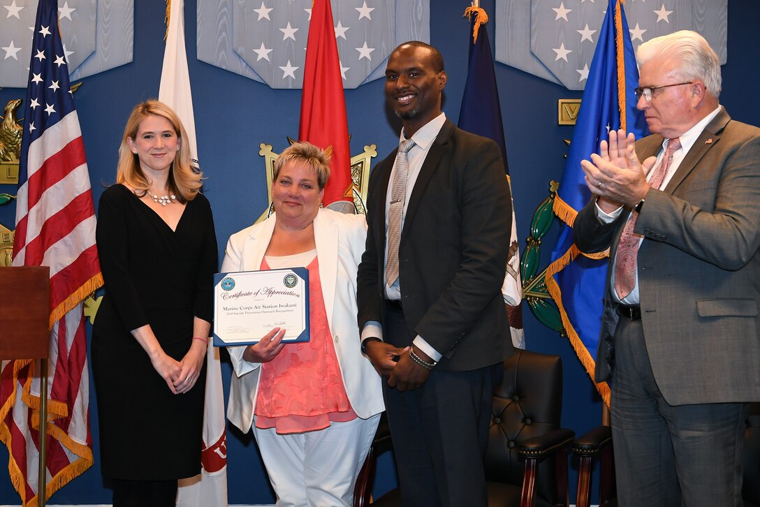 Award recipients hold a certificate.