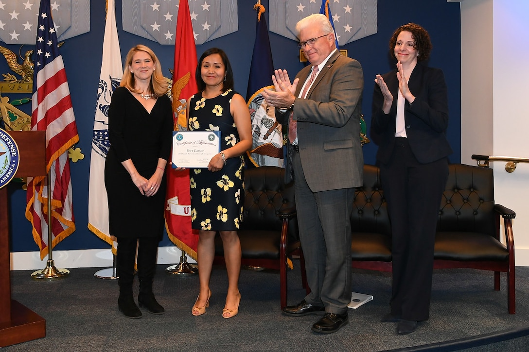 An award recipient holds a certificate.