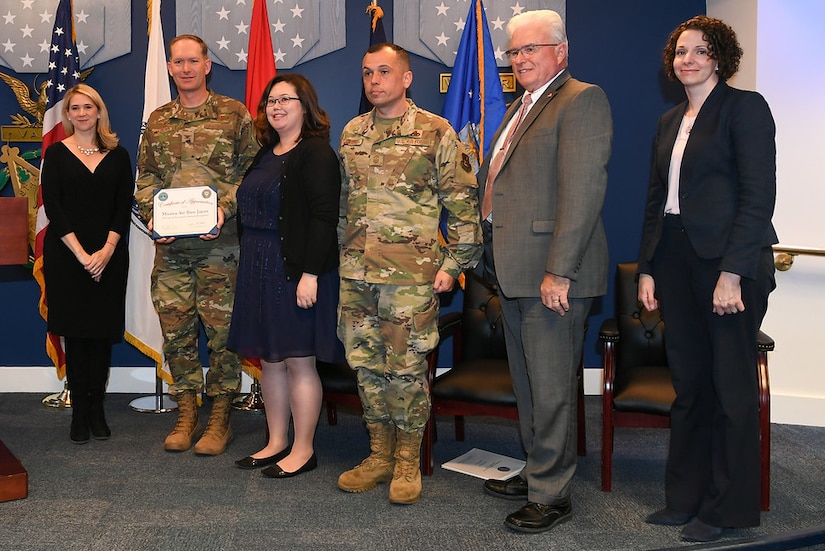 Award recipients hold a certificate.