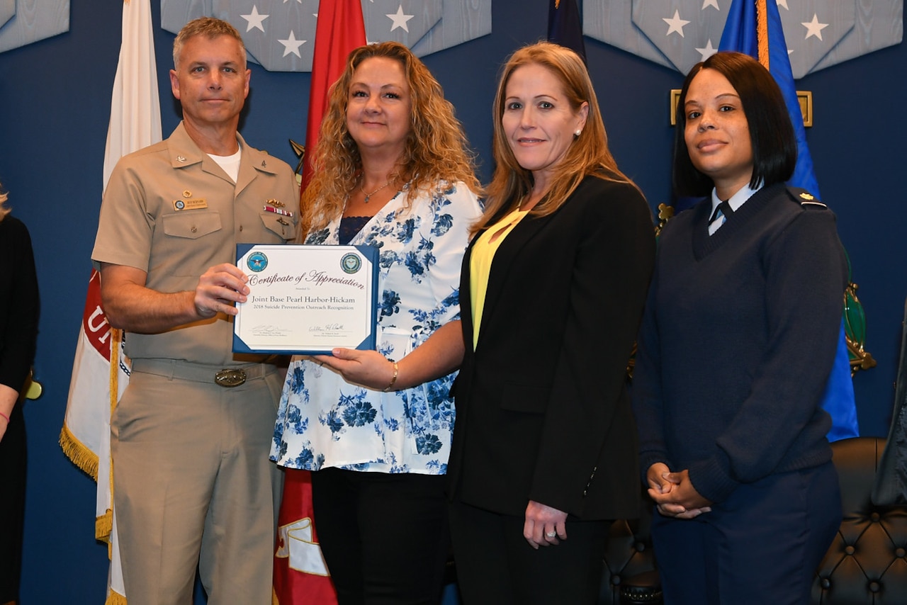 Award recipients hold a certificate representing their accomplishments.