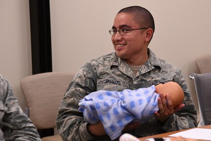 U.S. Air Force Staff Sgt. Mikel Dualos, 20th Medical Operations Squadron medical technician, holds a baby doll during a Dad’s 101 class, April 13, 2018. The class provides attendees the opportunity to learn from experienced fathers about topics such as managing stress, infant care, shaken baby syndrome and bonding with the baby while gaining hands-on practice.