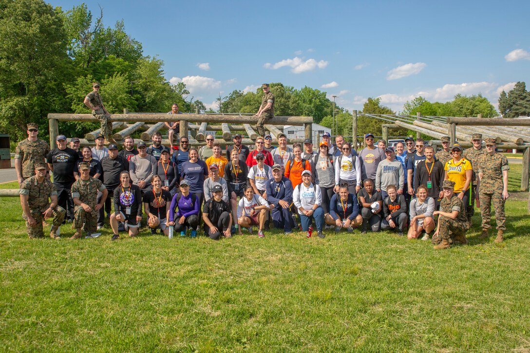 Coaches attending Marine Corps Recruiting Command’s 2019 Coaches Workshop pose for a group photo with Marines during the Coaches Workshop aboard Marine Corps Base Quantico, Virginia, May 16, 2019. The Coaches Workshop educates approximately 50 collegiate coaches from across the nation about essential Marine Corps leadership skills and programs that they can share with their student athletes based on first-hand experiences. (U.S. Marine Corps photo by Lance Cpl. Mitchell Collyer)