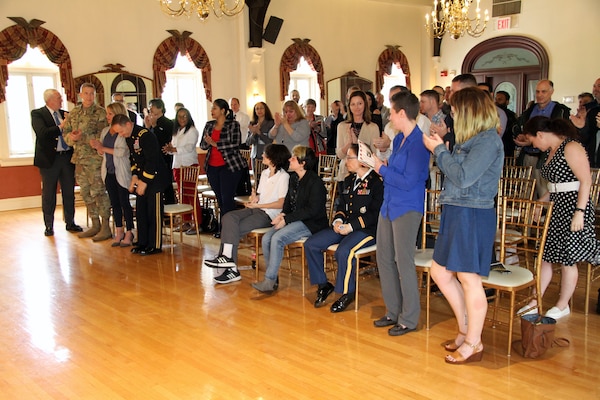 Ceremony attendees give Lt. Col. Julie D'Annunzio a standing ovation following remarks at her retirement ceremony held May 10, at the Fort Hamilton Community Club's Washington Room in Brooklyn, New York.