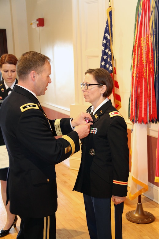 U.S. Army Corps of Engineers North Atlantic Division Commander Maj. Gen. Jeffrey Milhorn presents Lt. Col. Julie D'Annunzio with the Meritorious Service Medal during her retirement ceremony held May 10, at the Fort Hamilton Community Club's Washington Room in Brooklyn, New York.