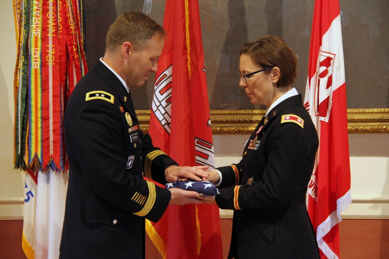 Lt. Col. Julie D'Annunzio (right) receives the traditional United States flag given to Army military retirees at the conclusion of their careers.