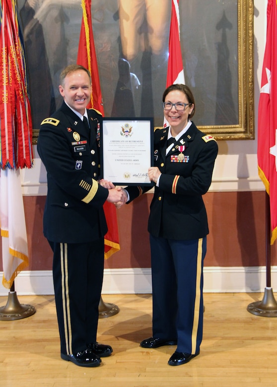 Lt. Col. Julie D'Annunzio (right) is presented with her certificate of retirement signed by U.S. Army Chief of Staff Gen. Mark Milley by Corps of Engineers North Atlantic Division (NAD) Commander Maj. Gen. Jeffrey Milhorn at a ceremony honoring her held May 10, at the Fort Hamilton Community Club's Washington Room in Brooklyn, New York.