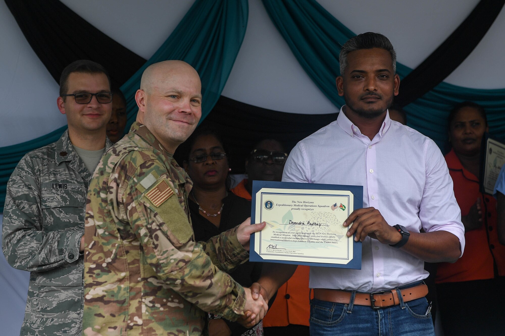 U.S. Air Force Lt. Col. Sean McNamara, Air Force Office of the Surgeon General, Falls Church, Virginia, presents Dr. Devendra Radhy, Port Mourant Hospital doctor in charge, with a certificate of appreciation during the closing ceremony of the ophthalmology center during New Horizons exercise 2019 at Port Mourant, Guyana, May 16, 2019. The ophthalmology clinic was established to provide aid to the Guyanese population by screening and selecting patients to receive cataract surgery in support of New Horizons 2019. The New Horizons exercise 2019 provides U.S. military members an opportunity to train for an overseas deployment and the logistical requirements it entails. The exercise promotes bilateral cooperation by providing opportunities for U.S. and partner nation military engineers, medical personnel and support staff to work and train side by side.(U.S. Air Force photo by Senior Airman Derek Seifert)