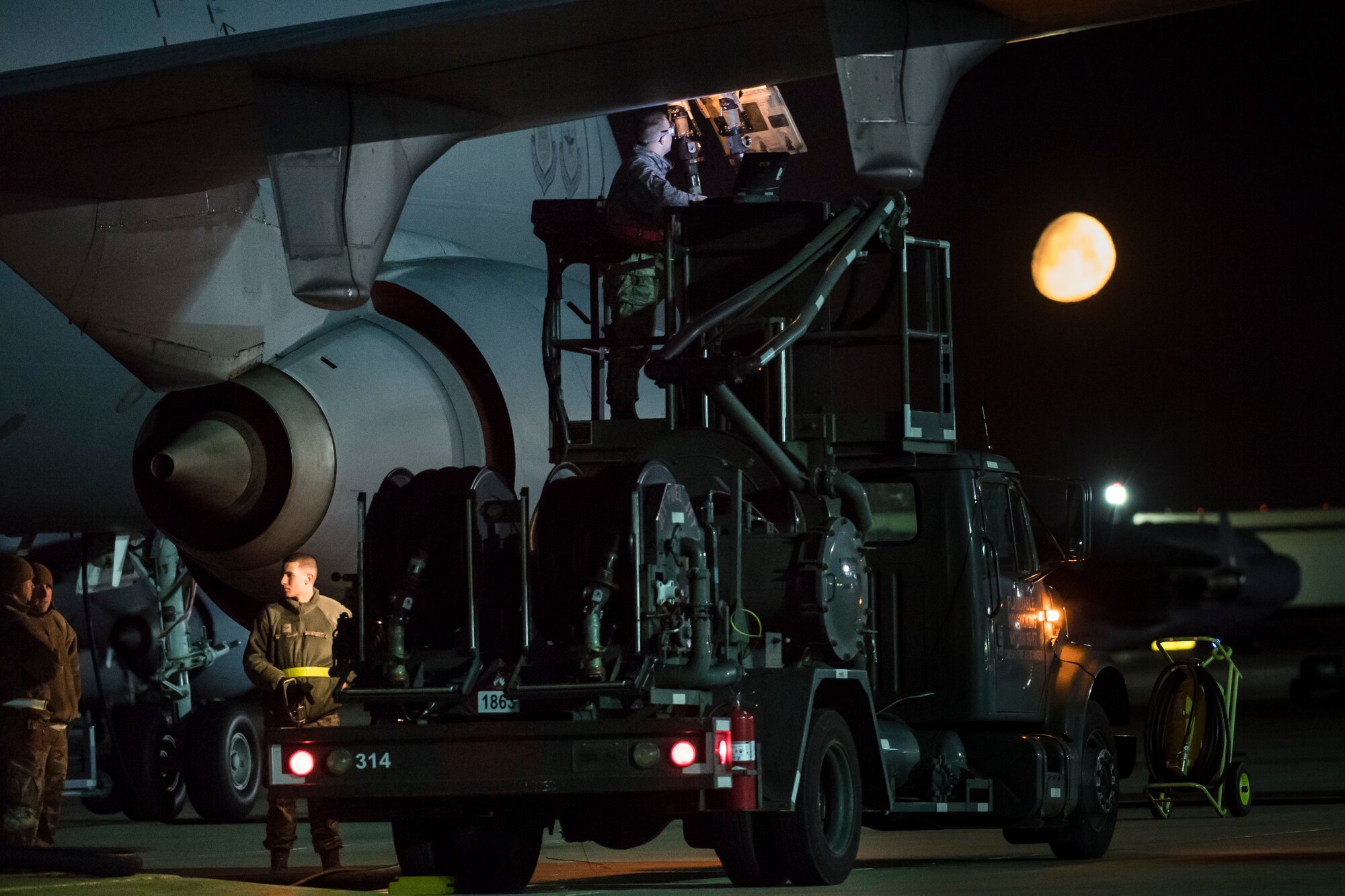 A near full moon sets over maintainers as they refuel a KC-10 Extender during their mid shift here at Joint Base McGuire-Dix-Lakehurst, May 15. Mid-shift maintainers work from 10 p.m. to 7 a.m. trouble shooting issues and performing maintenance checks to ensure the base's aircraft are ready to deploy at any given time. (U.S. Air Force photo by Christian DeLuca)