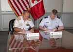 Military officers sign an agreement