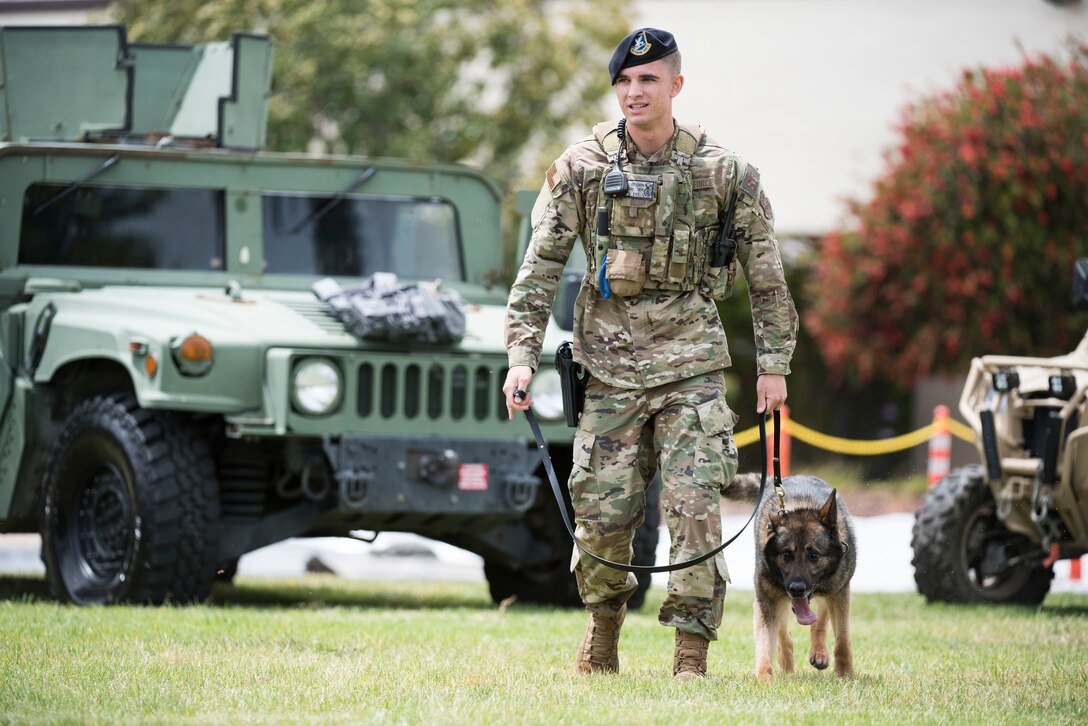 Staff. Sgt. Luke Gibson, 30th Security Forces Squadron military working dog handler, walks MWD Aramis during the Police Week Expo May 15, 2019, at Vandenberg Air Force Base, Calif. The Expo included a K-9 demonstration, which showcased the MWDs capabilities to take down a suspect. (U.S. Air Force photo by Airman 1st Class Hanah Abercrombie)