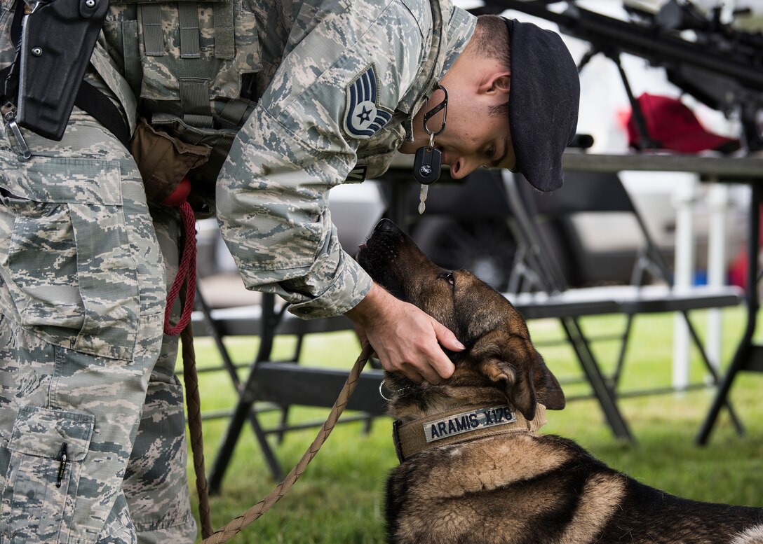 Staff Sgt. Matthew Rosado, 30th Security Forces Squadron military working dog handler, pets MWD Aramis May 15, 2019, at Vandenberg Air Force Base, Calif. The duo participated in the National Police Week police expo that highlighted 30th SFS, and local police agencies and their equipment. (U.S. Air Force photo by Airman 1st Class Hanah Abercrombie)