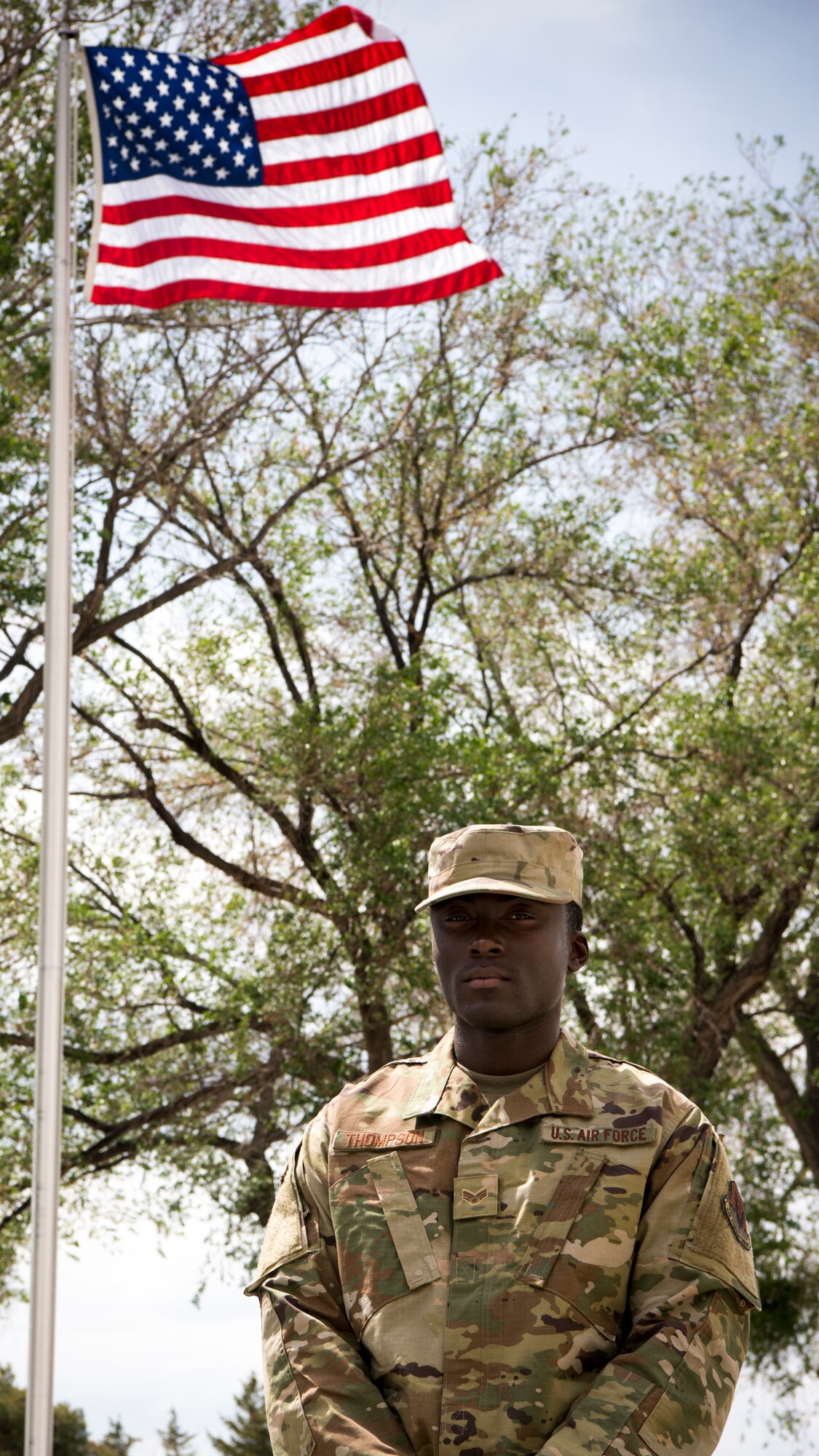 Senior Airman Jalen Thompson, 366th Maintenance Squadron aerospace ground equipment mechanic, stands by the American flag May 14, 2019, at Mountain Home Air Force Base. Thompson recently was awarded entry into the Airman Scholarship Commissioning Program that will pay for his college to become an officer in U.S. Air Force.