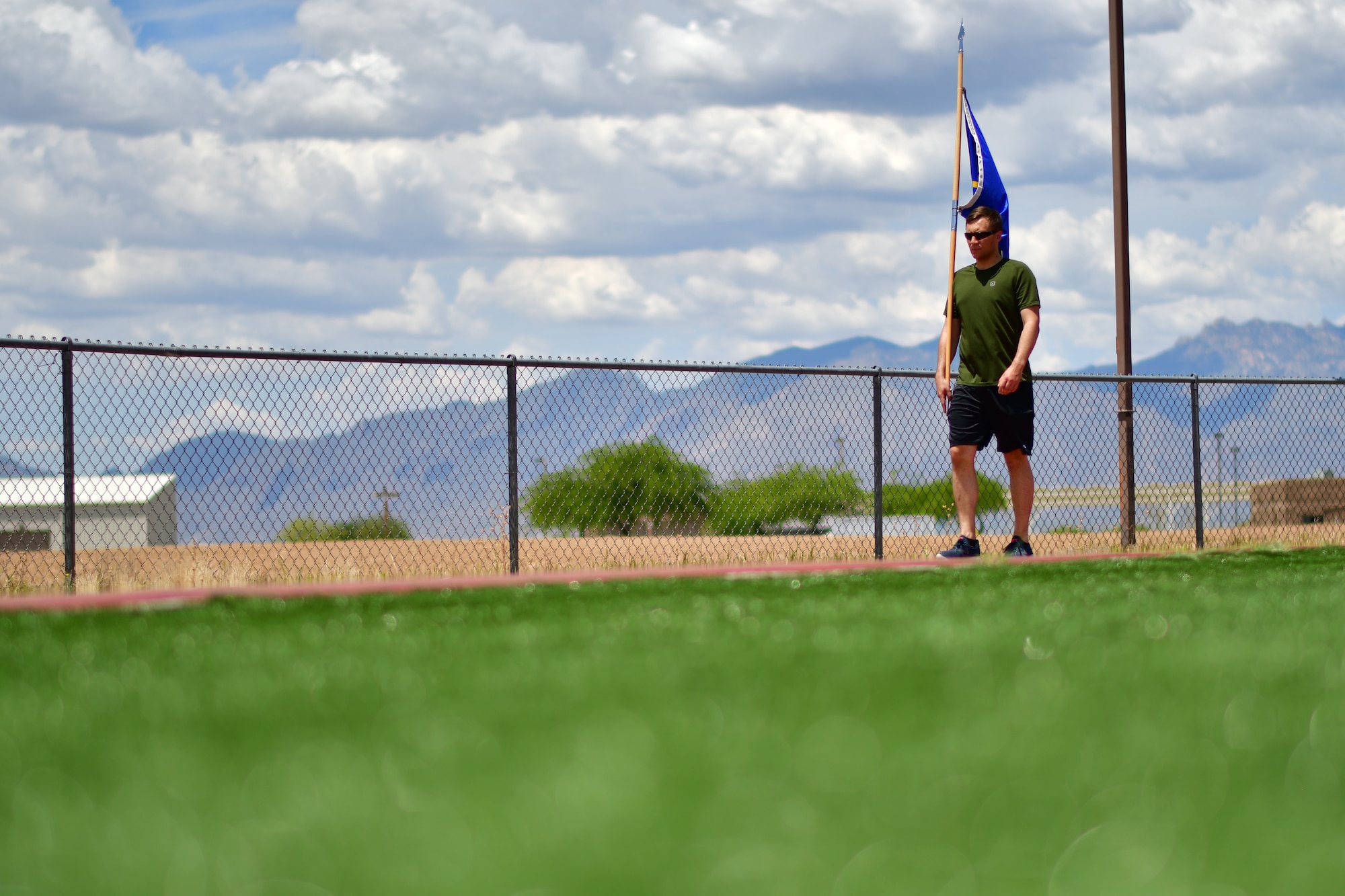 A U.S. Air Force 355th Security Forces defender carries a flag around the track at Davis-Monthan Air Force Base, Ariz., May 14, 2019.