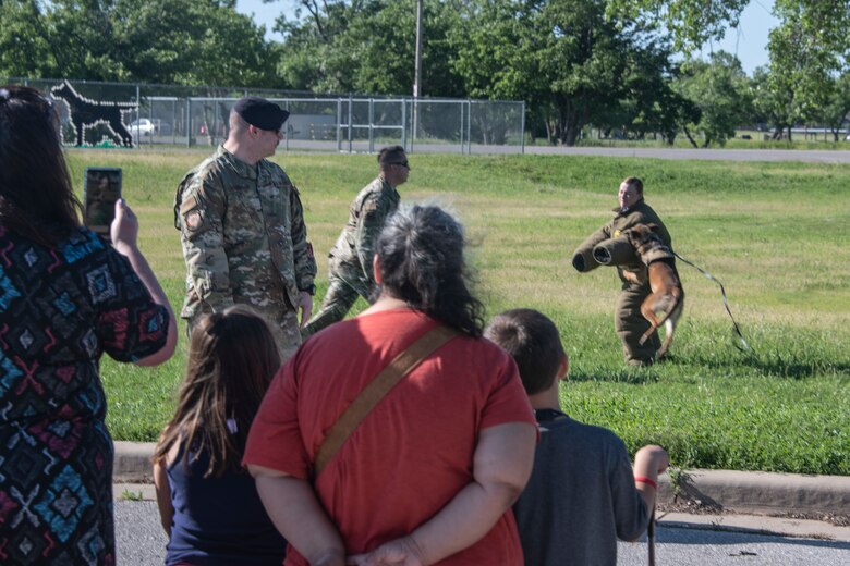 A Military Working Dog (MWD) assigned to the 97th Security Forces Squadron latches onto a simulated adversary, May 14, 2019, at Altus, Okla. A MWD is trained to wait for sudden movement or a verbal or hand movement command to grab and hold enemy forces until their handler can apprehend them. (U.S. Air Force photo by Senior Airman Cody Dowell)