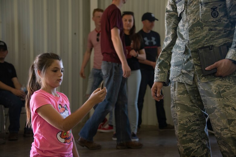 A child from the Altus community inspects one of the rounds the 97th Security Forces Squadron Combat Arms team utilizes, May 14, 2019, at Altus, Okla. There are 11 different weapon systems the instructors of 97th SFS Combat Arms team train on. (U.S. Air Force photo by Senior Airman Cody Dowell)