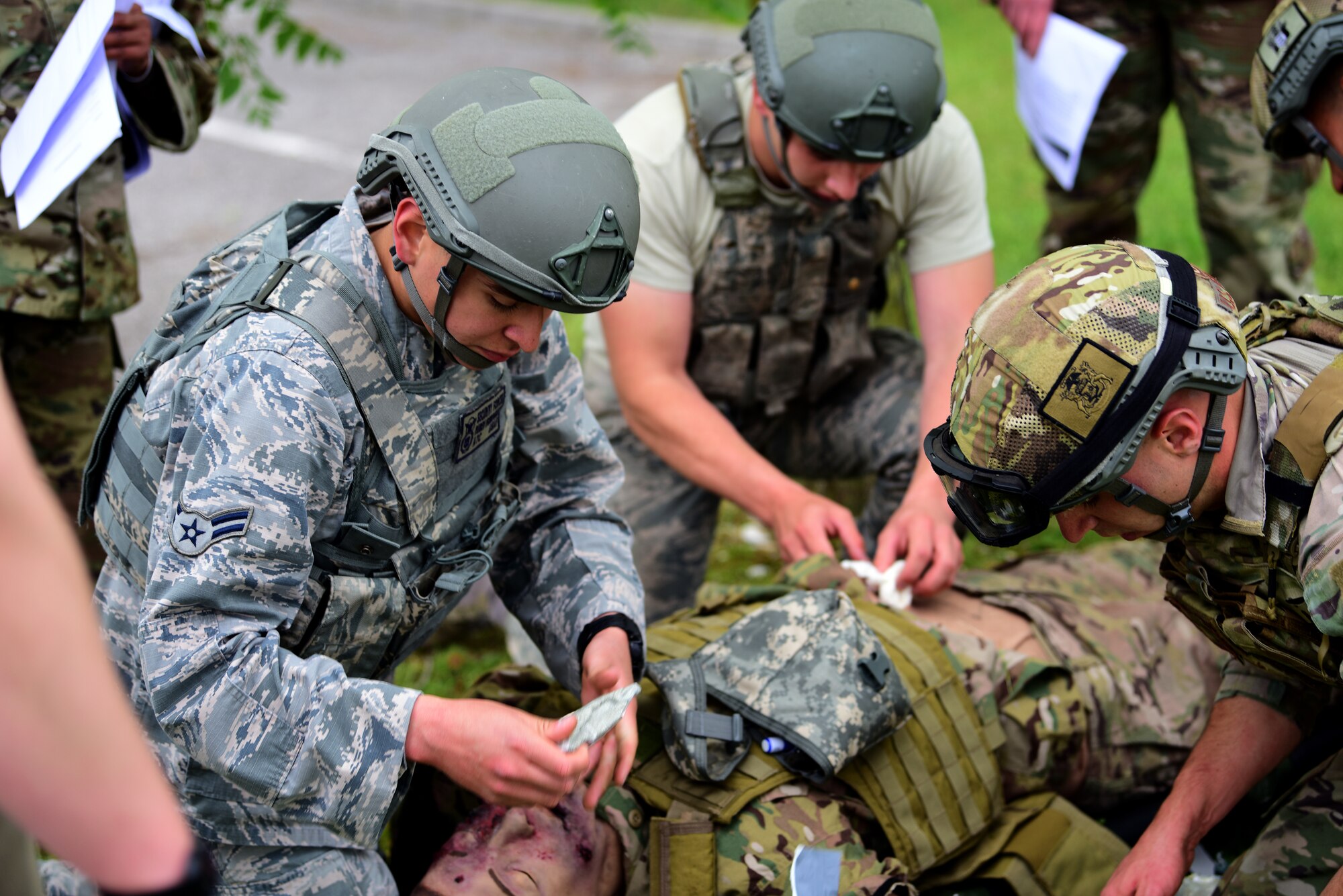 31st Security Forces Squadron Airmen perform aid on a training dummy to test their first aid abilities during the Police Week Combat Challenge that pit security forces Airmen against Joint International Non Commissioned Officers Development Course on May 15, 2019 at Aviano Air Base, Italy. Participates were tested on treating wounds, applying a tourniquet and other forms of first aid. (U.S. Air Force photo by Airman 1st Class Caleb House)