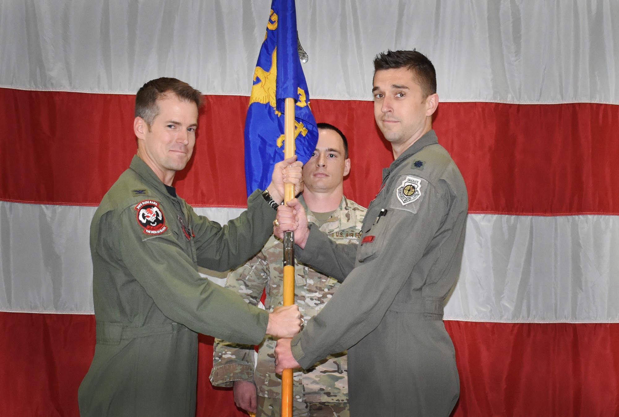 Col. Joshua Wood, 388th Fighter Wing Operations Group commander, left, passes the guidon of the 34th Fighter Squadron to Lt. Col. Aaron Cavasos, as he takes command of the “Rude Rams” May 17, 2019. Cavasos previously served as the director of operations for the squadron. The 34th Fighter Squadron was the first of the 388th FW units to stand up as an operational F-35A Lightning II Squadron in 2015. Cavasos is the 3rd commander since then. Lt. Col. Matthew Johnston relinquished command and is headed to another assignment in Washington, D.C.