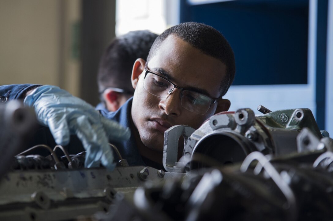 International students work on a diesel engine.