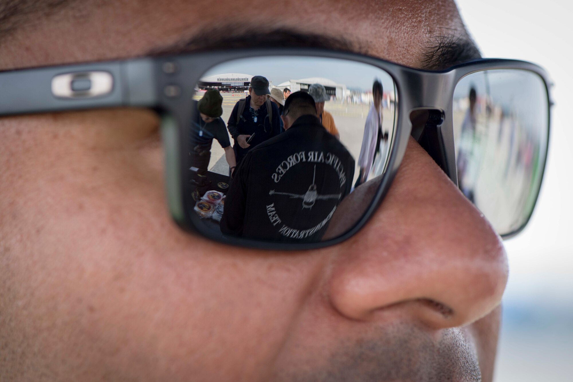 U.S. Air Force Tech. Sgt. Esteban Ramirez, a 14th AMU aerospace propulsion system specialist and Pacific Air Forces F-16 Fighting Falcon Demonstration Team member, watches Staff Sgt. Mario Perez, a 13th Aircraft Maintenance Unit F-16 Fighting Falcon avionics specialist and PACAF F-16 Demo Team announcer, pass out memorabilia to event spectators at the 43rd Japan Maritime Self-Defense Force – Marine Corps Air Station Iwakuni Friendship Day 2019 at MCAS Iwakuni, May 5, 2019. The PACAF F-16 Demonstration Team performs at multiple events a year, however, this event offered joint and bilateral cohesion. (U.S. Air Force photo by Senior Airman Collette Brooks)