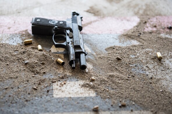 A handgun rests on the ground among shell casings during a shooting competition on May 17, 2019, at Incirlik Air Base, Turkey. The 39th Security Forces Squadron hosted the event, which was designed to give non-security forces Airmen a taste of the stress law enforcement officers feel when faced with using deadly force. (U.S. Air Force photo by Senior Airman Joshua Magbanua)