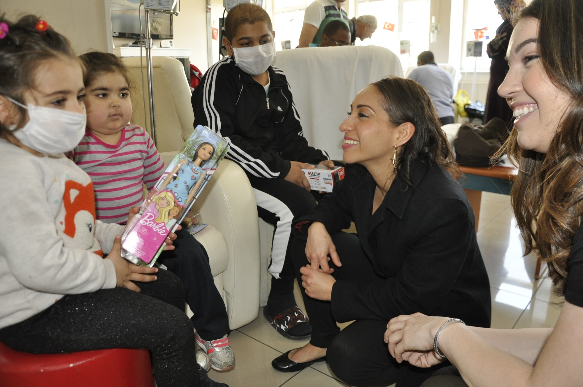 Capt. Michelle Cazares, 425th Air Base Squadron director of operations, and Tech. Sgt. Renee Deffenbaugh, 425th ABS Logistics, hand out dolls and toys to more than 60 children at Dr. Behçet Uz children’s hospital during a community outreach April 18, 2019. The event was designed to show community support for the children who were being treated for a variety of different medical reasons in wards that included leukemia, pediatric surgery and the infectious diseases units.(U.S. Air Force photo by Tanju Varlıklı)