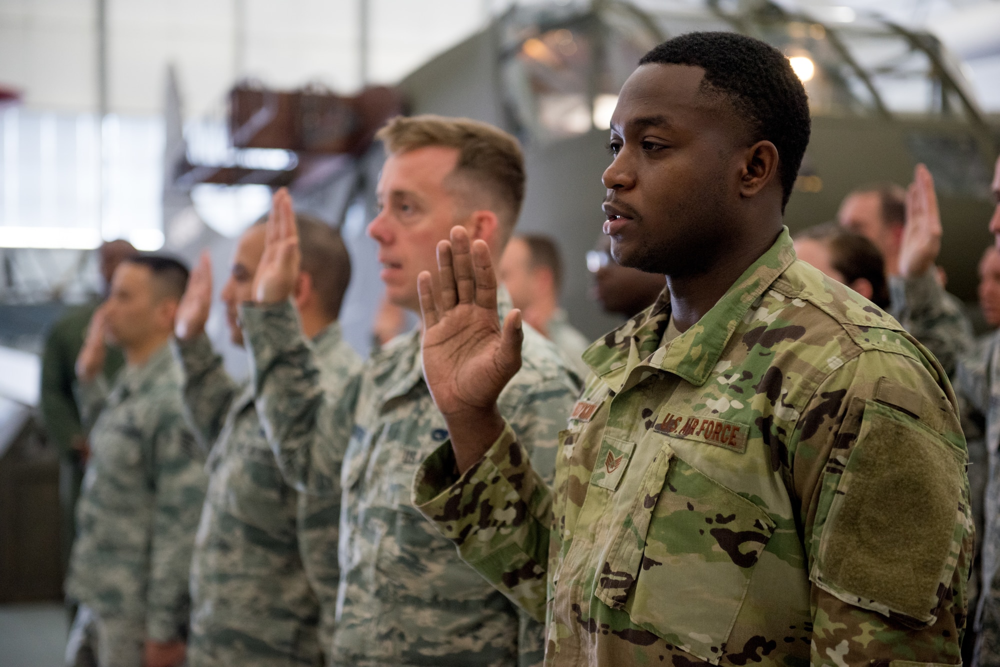 Airmen from the 512th Airlift Wing raise their right hands during a non-commissioned officer induction ceremony held at the Air Mobility Command Museum in Dover, Del., May 19, 2019. Seventy-seven newly promoted staff sergeants were charged with new responsibilities as they accepted the role within their new rank. (U.S. Air Force photo by Capt. Katie Spencer)