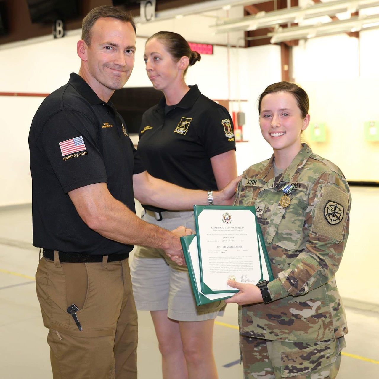 Soldiers pose with certificates.