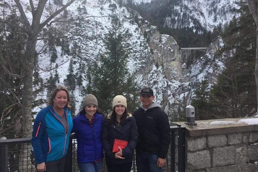 A group poses for a photo in the mountains.