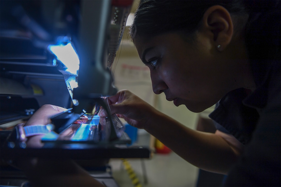 A sailor uses an embroidery machine.