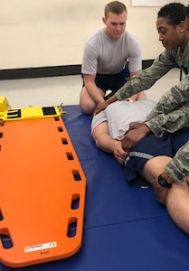 Airman 1st Class Colten Connelly simulates a c-spine stabilization on a “patient” during emergency medical technician training in the Aerospace Service Medical Apprentice program at the Medical Education and Training Campus. The technique is the same one he administered to a vehicle accident victim. The purpose of this skill is to prevent further injury to patients involved in a trauma. When this skill is completed appropriately, the patient is unable to move and will stay on the backboard until a physician evaluates them for spinal injuries.