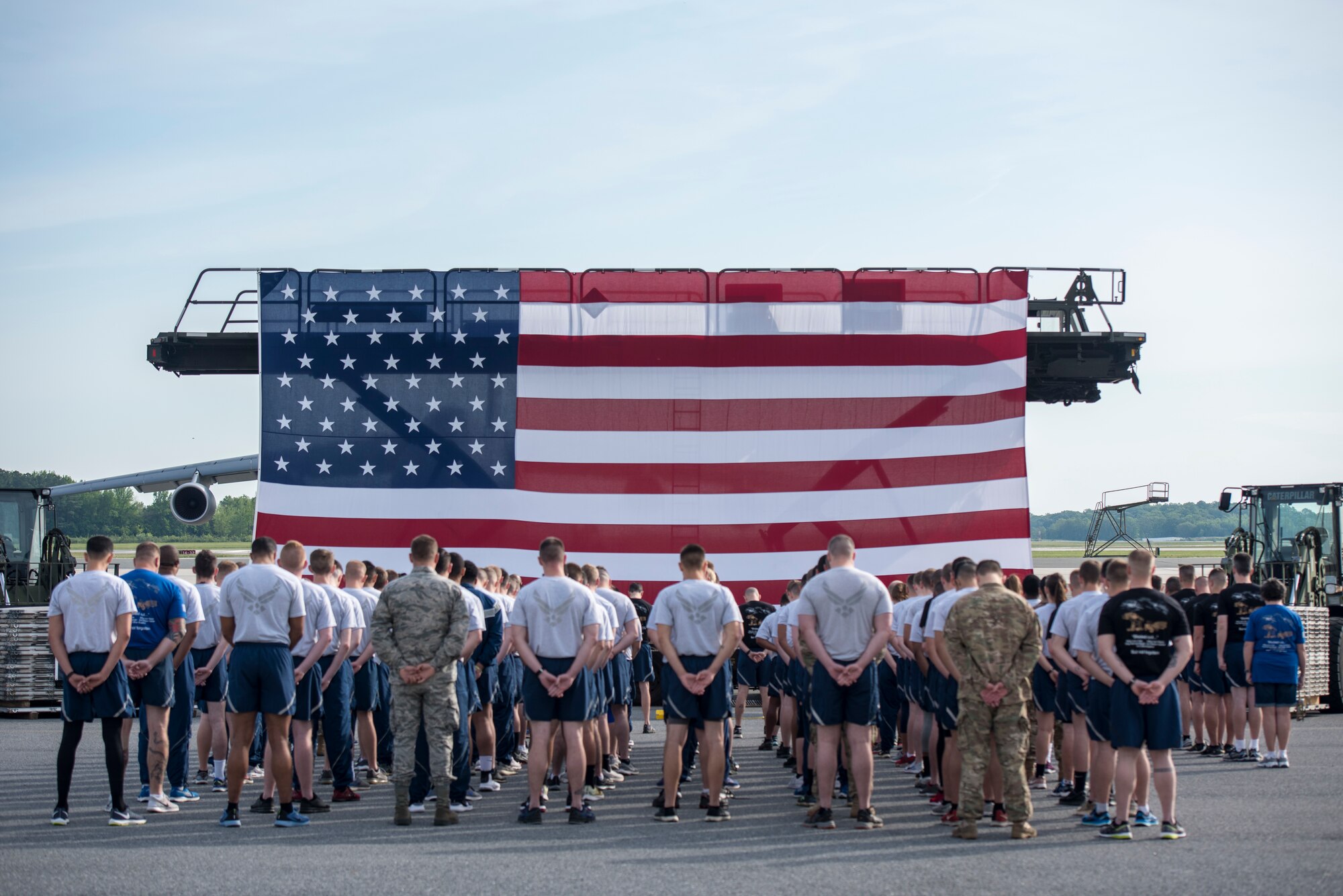 436th Air Transportation Airmen stand in front of an American Flag.