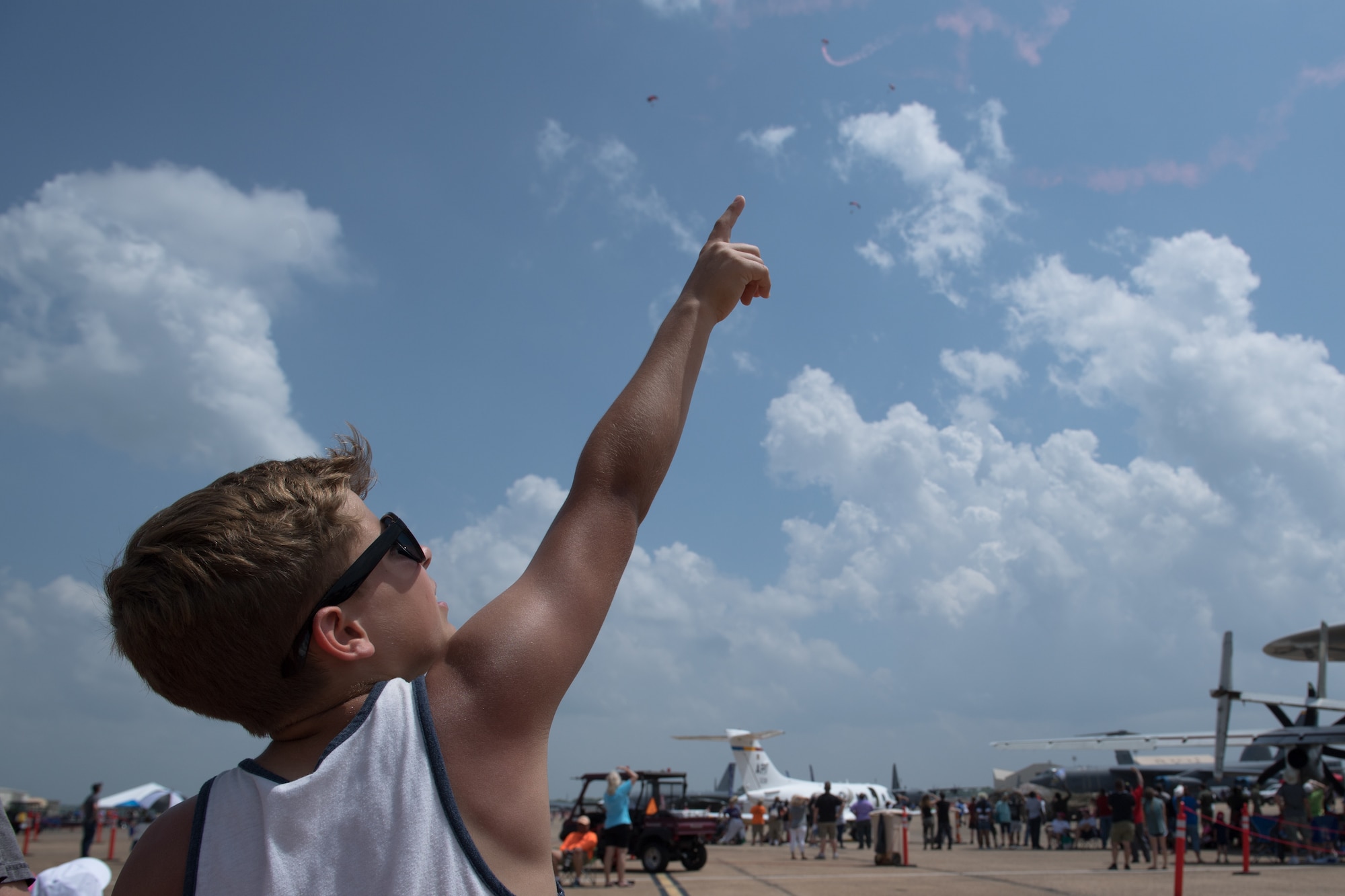 A spectator watches the U.S. Army Special Operations Command Black Daggers Parachute Demonstration Team perform during the Defenders of Liberty Air & Space Show at Barksdale Air Force Base, La., May 19, 2019.  The airshow was first held in 1933 and is a full weekend of military and civilian aircraft and performances and displays. (U.S. Air Force photo by Senior Airman Stuart Bright)