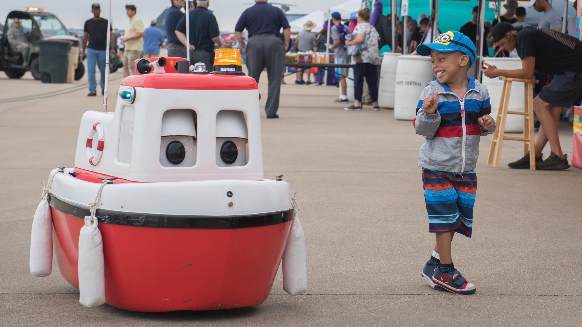 A child laughs at the U.S. Army Corps of Engineers water safety mascot, Cory the Tugboat, during the Defenders of Liberty Air and Space Show at Barksdale Air Force Base, La., May 18, 2019. Visitors had the opportunity to experience flyovers, performances and static displays from numerous bases. (U.S. Air Force photo by Tech. Sgt. Daniel Martinez)