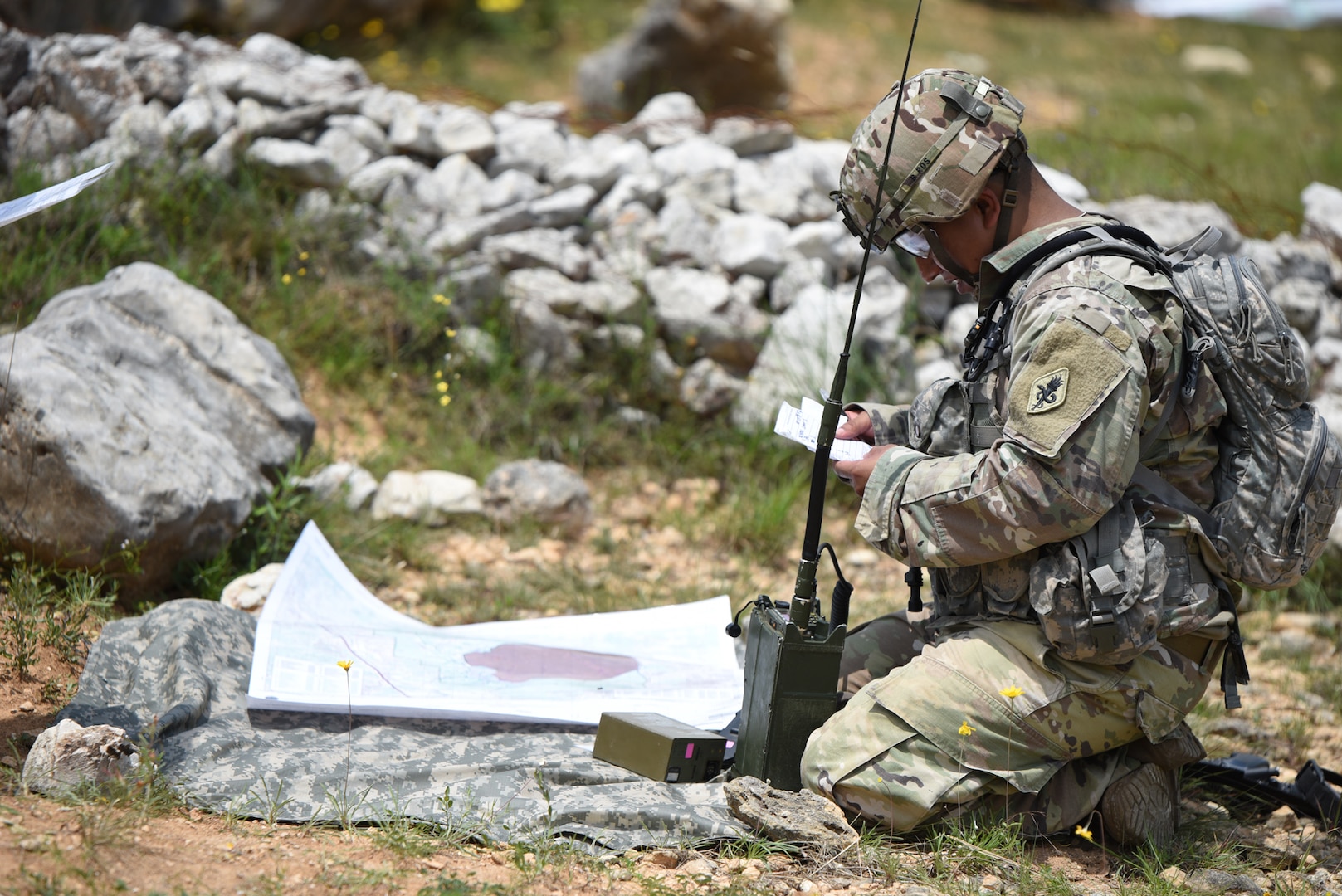 A Soldier assigned to the Training Support Activity, Army Medical Department Center & School, Health Readiness Center of Excellence, training at Joint Base San Antonio-Camp Bullis, reviews a 9 Line MEDEVAC request before calling it in over a radio.