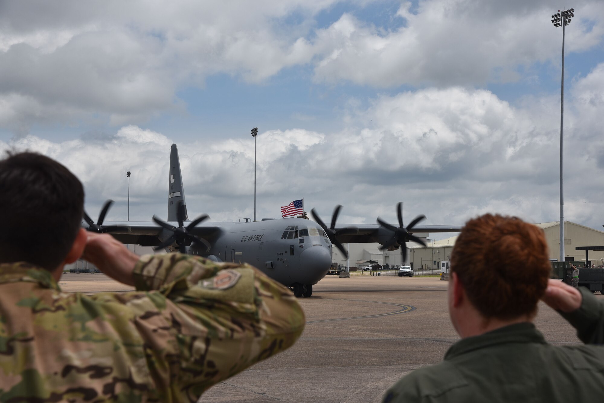 U.S. Air Force Reserve Col. Christopher Lay, 913th Airlift Group commander, and Lt. Col. Elissa Granderson, 327th Airlift Squadron director of operations, salute an oncoming C-130J at Little Rock Air Force Base, Arkansas, May 19, 2019