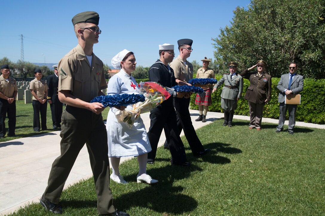 U.S. Marines and Sailors with Special Purpose Marine Air-Ground Task Force-Crisis Response-Africa 19.2, Marine Forces Europe and Africa, and an Italian nurse march to place wreaths on a cemetery memorial during a wreath-laying ceremony in Siricusa, Italy, May 11, 2019. Community leaders in Syracuse invited the Marines and Sailors with SPMAGTF-CR-AF 19.2 to participate in a wreath-laying ceremony to honor allied soldiers that died during World War II. (U.S. Marine Corps photo by Staff Sgt. Mark E. Morrow Jr.)
