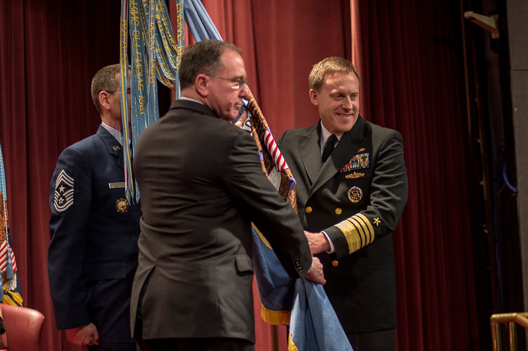 ADM Michael Rogers, USN, accepts the NSA flag from Dr. Michael Vickers, USDI, as he assumes responsibility for NSA, 03 April 2014