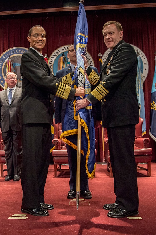 ADM Michael Rogers, USN, accepts the U.S. Cyber Command Flag from ADM Cecil Haney, USN, Commander, U.S. Strategic Command, as he assumes command, 03 April 2014