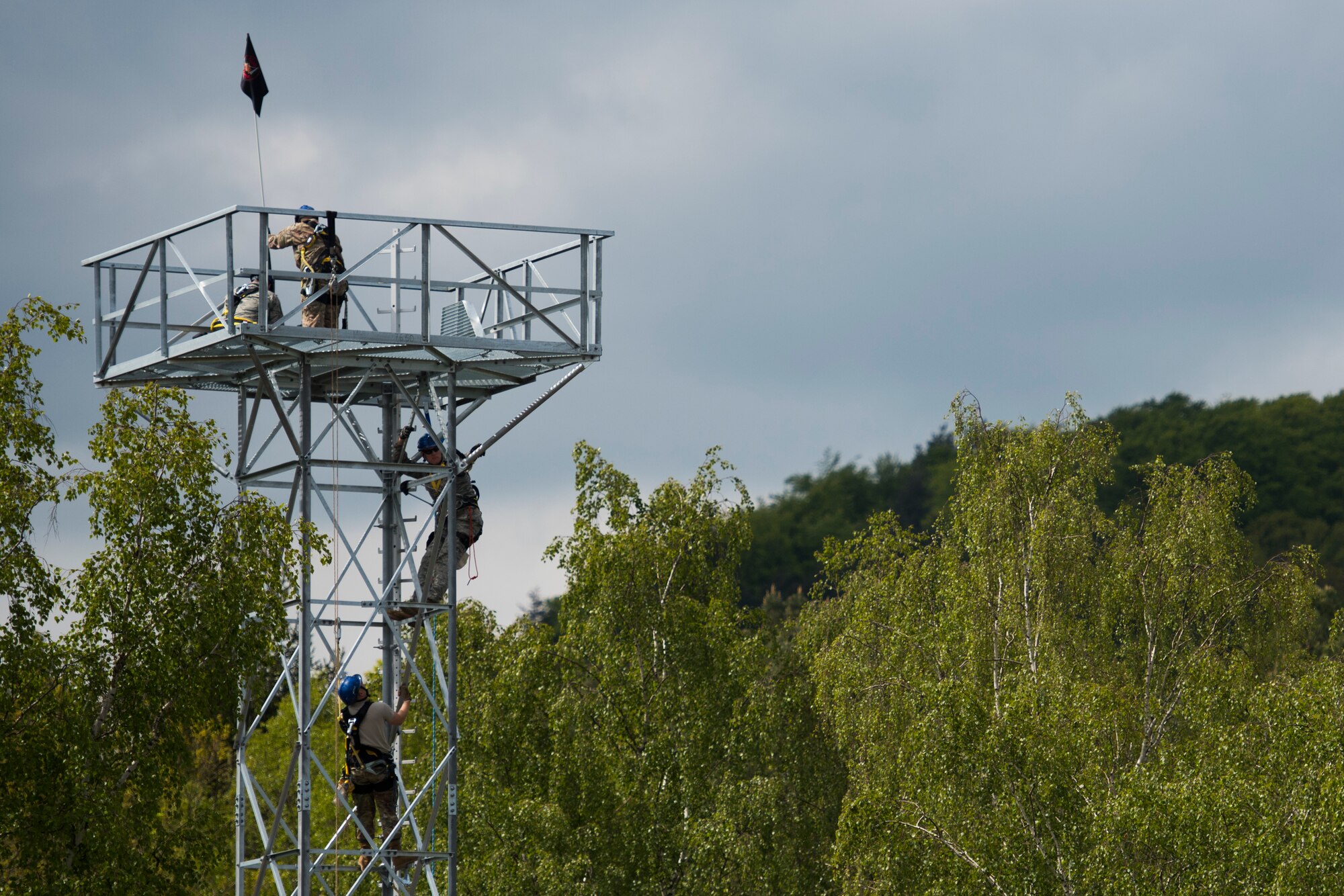 U.S. Air Force Airmen from the 1st Communication Maintenance Squadron climb the newly constructed training tower on its inaugural day following a ribbon-cutting ceremony hosted by Lt. Col. Michael Williams, 1st CMXS commander, on Kapaun Air Station, Germany, May 17, 2019. The training tower is projected to save the 1st CMXS approximately $22,500 annually due to costs saved on temporary duty assignments for training. (U.S. Air Force photo by Senior Airman Kristof J. Rixmann)