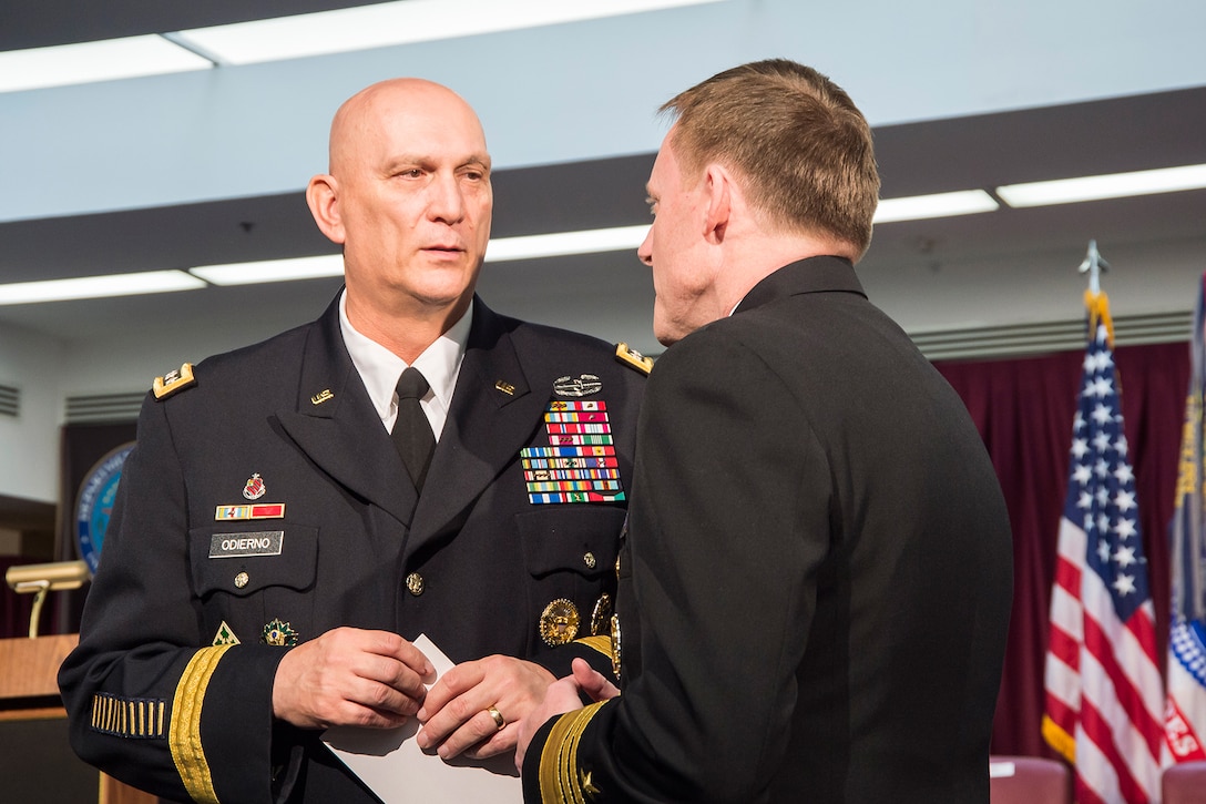 Army Chief of Staff GEN Raymond Odierno, attending the retirement ceremony for GEN Keith Alexander, USA, on March 28, 2014, exchanges a few words with then Commander, Fleet Cyber Command/10th Fleet, VADM Michael Rogers, USN