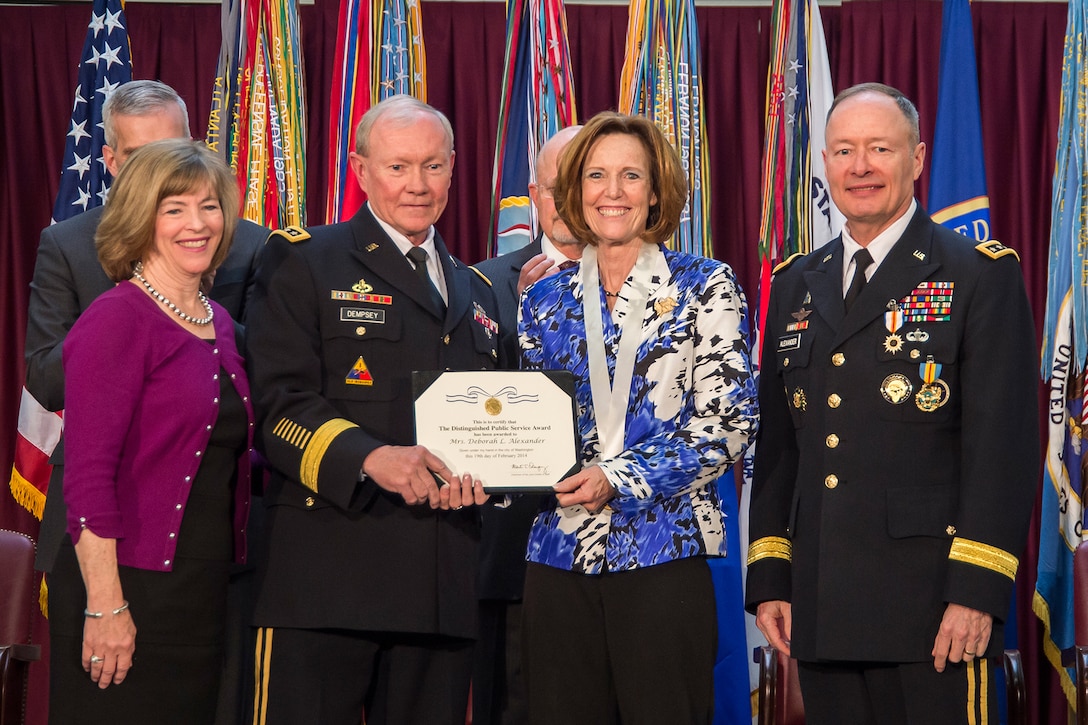 Chairman of the Joint Chiefs of Staff, GEN Martin Dempsey, USA, and Mrs. Deanie Dempsey award Mrs. Debbie Alexander the Distinguished Public Service Award on the retirement of GEN Keith Alexander, USA, March 28, 2014